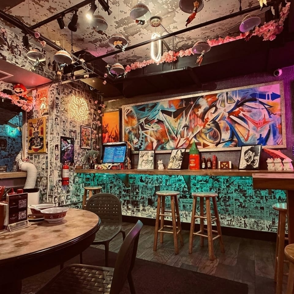 A vibrant, anime-themed restaurant interior with manga-covered walls, neon lights, and colorful graffiti art.