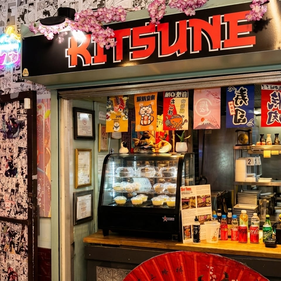 The Kitsune restaurant entrance, featuring a vibrant manga-covered wall and a food display.